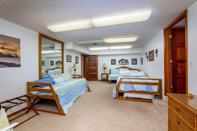 bedroom with carpet floors, visible vents, a textured ceiling, and an AC wall unit