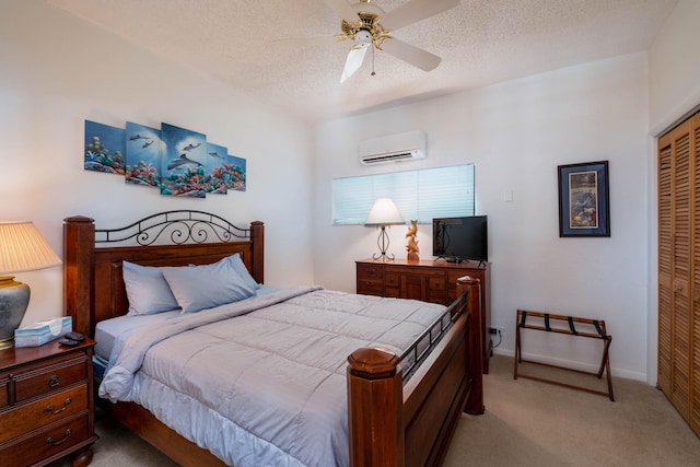 bedroom with light colored carpet, ceiling fan, a wall mounted air conditioner, a textured ceiling, and a closet