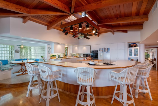 kitchen with wooden ceiling, white refrigerator with ice dispenser, white cabinets, and black oven