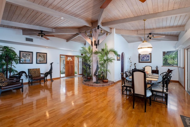 dining space with arched walkways, light wood-style flooring, visible vents, and a ceiling fan