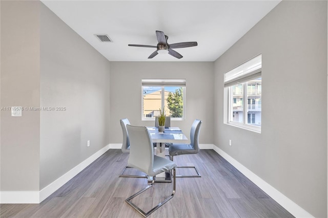 dining area with ceiling fan and dark hardwood / wood-style flooring