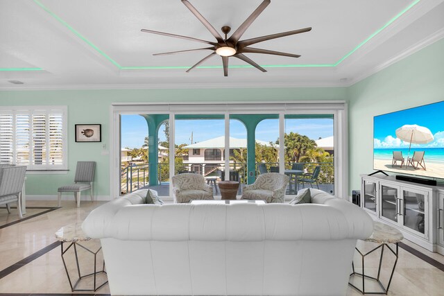 living room with crown molding and a tray ceiling