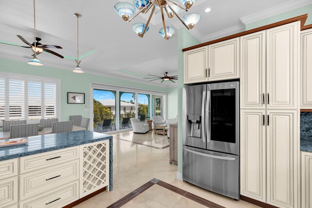 kitchen with stainless steel refrigerator with ice dispenser, crown molding, hanging light fixtures, dark stone counters, and ceiling fan with notable chandelier