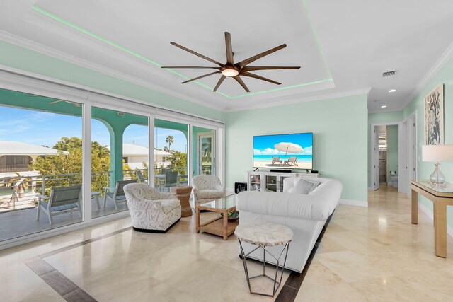 living room featuring a tray ceiling and ornamental molding