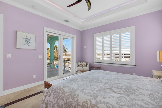 bedroom with ceiling fan, a tray ceiling, and access to exterior