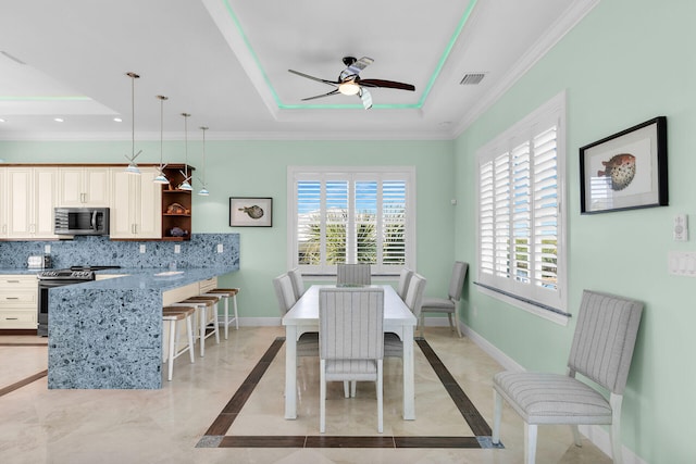 dining room featuring crown molding, a raised ceiling, and ceiling fan