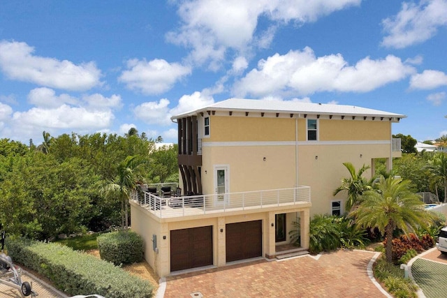 back of house with a garage and a balcony