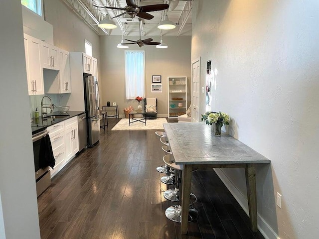 kitchen with appliances with stainless steel finishes, sink, ceiling fan, dark hardwood / wood-style flooring, and white cabinets