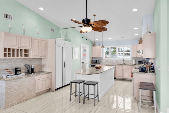 150 10th St, Key Colony, FL 33051 - kitchen with paneled built in refrigerator, stainless steel microwave, a sink, backsplash, and vaulted ceiling