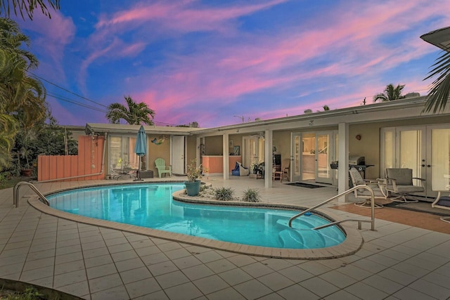 pool at dusk with a patio