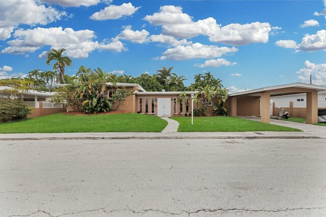 view of front of property featuring a front lawn and a carport