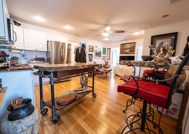 1124 Catherine St Unit 202, Key West, FL 33040 - kitchen featuring ceiling fan, appliances with stainless steel finishes, white cabinetry, light wood-type flooring, and dark countertops