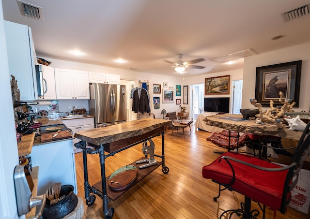 1124 Catherine St Unit 202, Key West, FL 33040 - kitchen with appliances with stainless steel finishes, a sink, a ceiling fan, white cabinetry, and light wood-style flooring