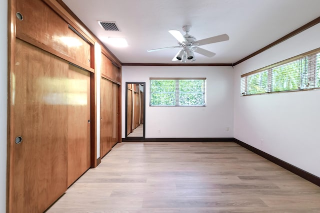 1110 Johnson St, Key West, FL 33040 - unfurnished bedroom featuring multiple windows, crown molding, light wood-style floors, baseboards, and two closets