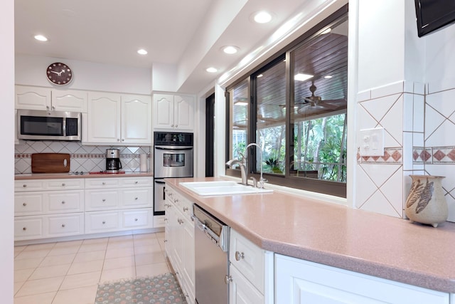 1110 Johnson St, Key West, FL 33040 - kitchen featuring stainless steel appliances, a sink, backsplash, recessed lighting, and white cabinetry