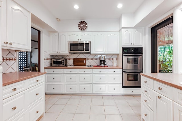 1110 Johnson St, Key West, FL 33040 - kitchen with stainless steel appliances, tasteful backsplash, light countertops, white cabinets, and recessed lighting
