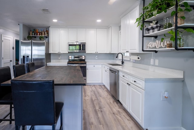 45 1st St, Big Coppitt, FL 33040 - kitchen with open shelves, light wood-style floors, white cabinets, a sink, and appliances with stainless steel finishes