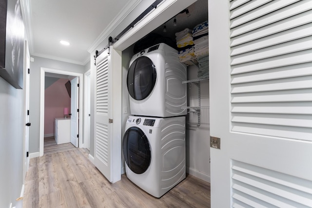 45 1st St, Big Coppitt, FL 33040 - clothes washing area featuring crown molding, stacked washer and dryer, laundry area, a barn door, and baseboards