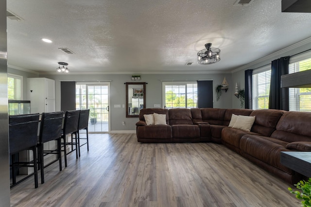 45 1st St, Big Coppitt, FL 33040 - living room featuring an inviting chandelier, crown molding, visible vents, wood finished floors, and a wealth of natural light