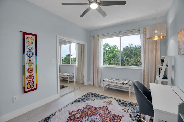 tiled home office featuring ceiling fan