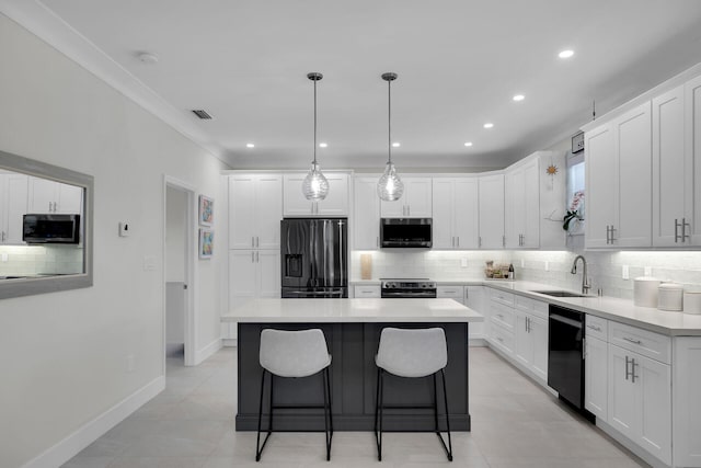 kitchen with white cabinetry, sink, a kitchen island, and black appliances