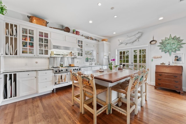 dining space featuring recessed lighting, wood finished floors, and french doors