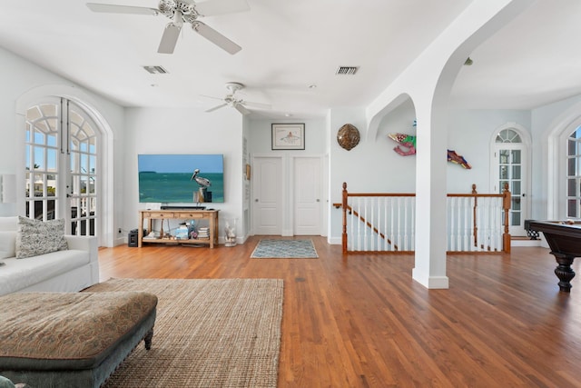 living room with wood finished floors, visible vents, and a healthy amount of sunlight