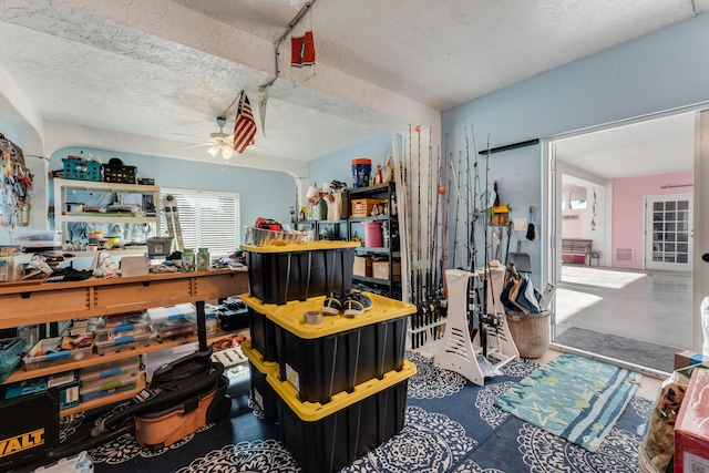 misc room with finished concrete floors, a textured ceiling, and a ceiling fan