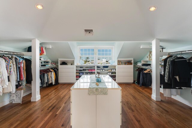 spacious closet featuring visible vents, vaulted ceiling, and dark wood-style flooring