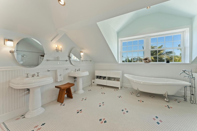 full bath featuring vaulted ceiling, a freestanding bath, and wainscoting