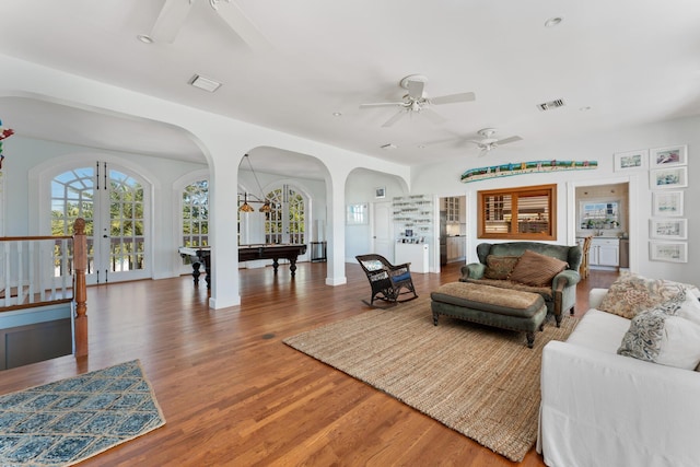 living room featuring ceiling fan, visible vents, wood finished floors, and french doors