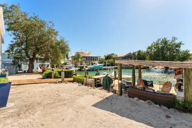 view of yard with a water view and a boat dock