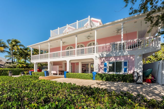 rear view of house featuring a carport, ceiling fan, and a balcony