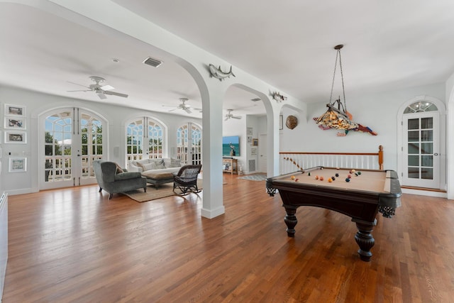 rec room with baseboards, visible vents, arched walkways, wood finished floors, and french doors