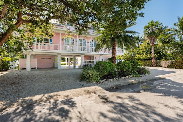 view of front of home with driveway and a balcony