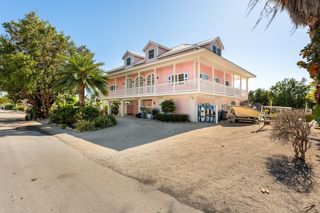 view of front of home featuring a carport, driveway, and a balcony