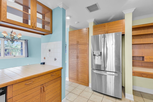 1514 Shaw Dr, Key Largo, FL 33037 - kitchen with stainless steel refrigerator with ice dispenser, tile countertops, light tile patterned floors, glass insert cabinets, and crown molding