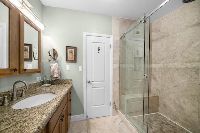 bathroom featuring baseboards, a shower stall, and vanity