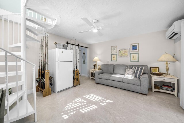 living area featuring plenty of natural light, a textured ceiling, an AC wall unit, and light tile patterned flooring