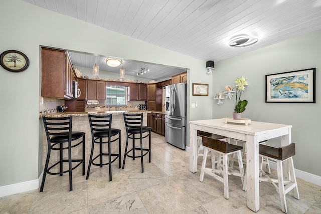 kitchen with baseboards, decorative backsplash, wood ceiling, light stone counters, and stainless steel appliances