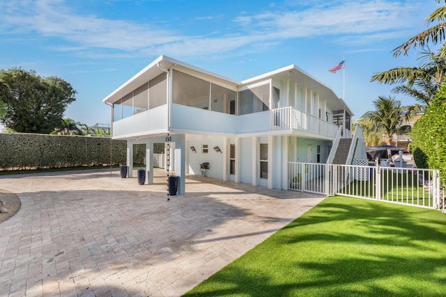 back of property with stairs, fence, and a lawn