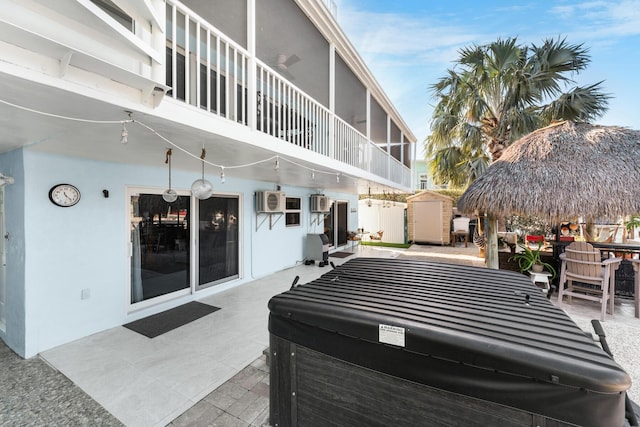 view of patio featuring a bar, a hot tub, a storage unit, and an outdoor structure