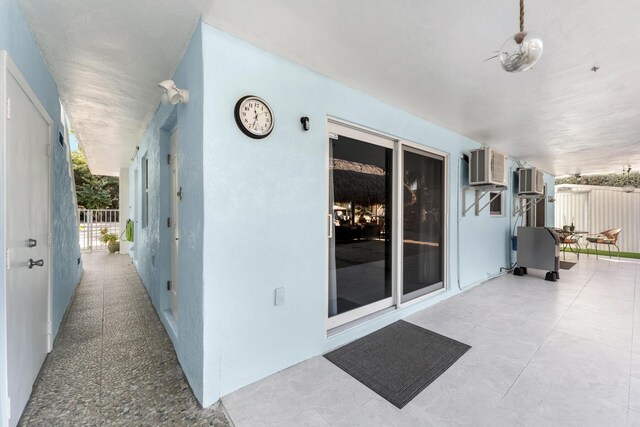 exterior space featuring a yard, a patio, stucco siding, fence, and a wall mounted air conditioner