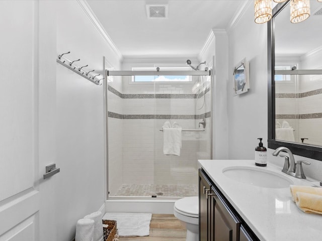 bathroom featuring ornamental molding, toilet, a stall shower, wood finished floors, and vanity