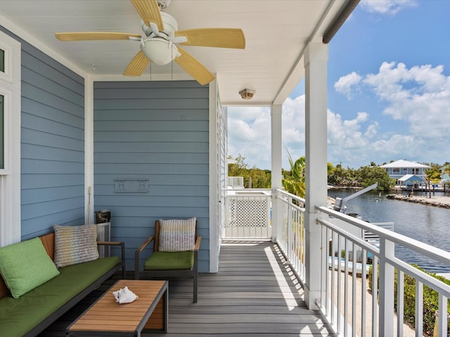 balcony featuring a water view and a ceiling fan