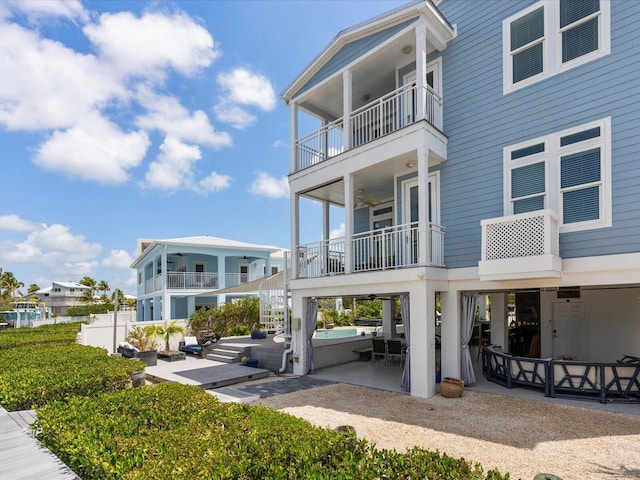 back of property with a balcony, a patio area, stairs, and ceiling fan