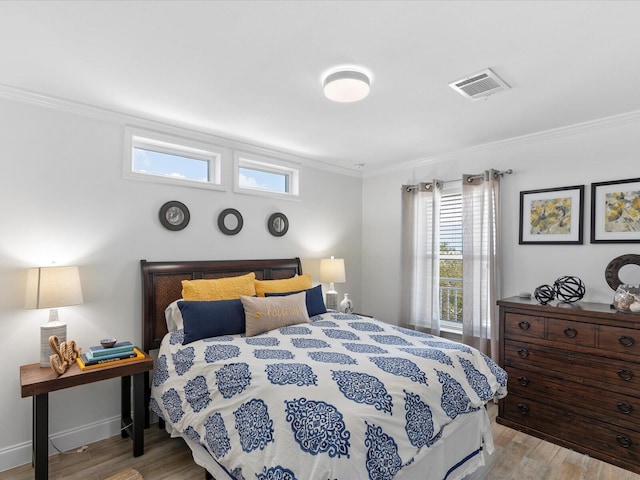 bedroom featuring wood finished floors, ornamental molding, multiple windows, and baseboards