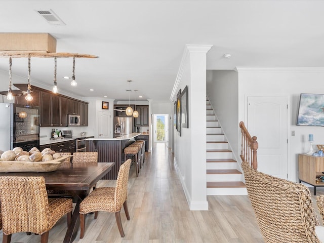 dining space featuring light wood-style flooring, baseboards, recessed lighting, ornamental molding, and stairs