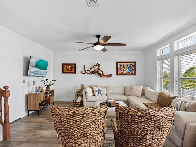 living room with a ceiling fan, ornamental molding, and wood finished floors