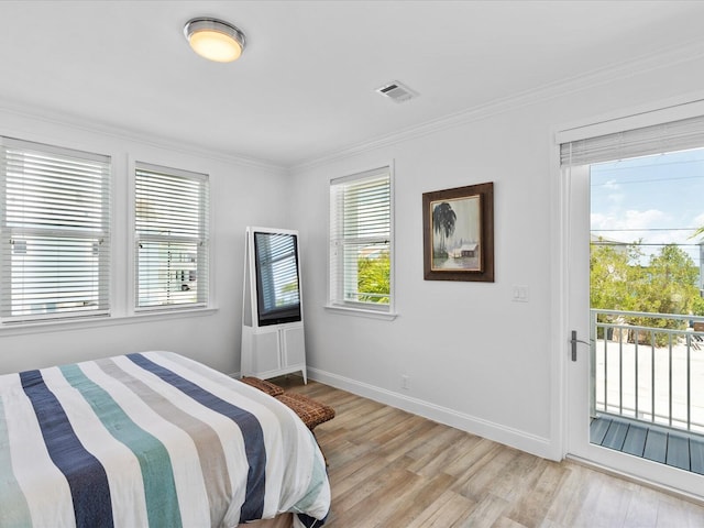 bedroom with access to exterior, crown molding, light wood-type flooring, and baseboards